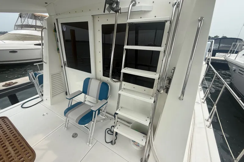 Slide: The Image of 2006 Island Pilot 395 yacht deck with ladder and striped chairs. - 11
