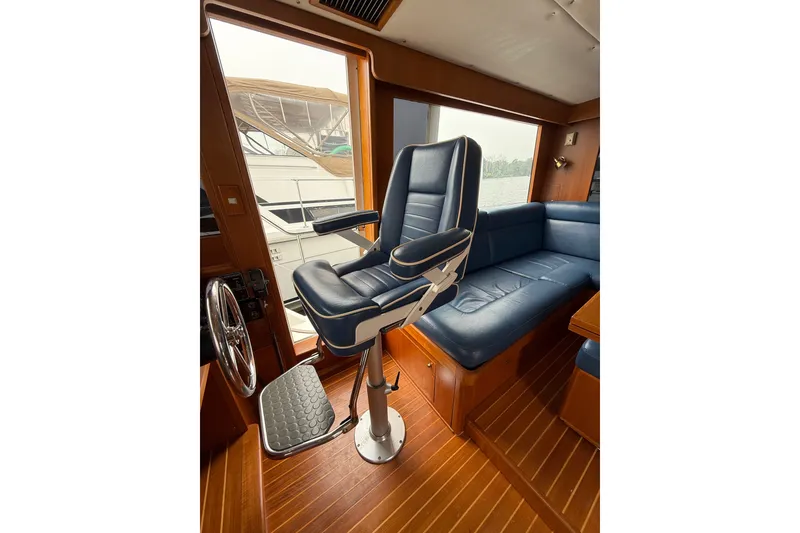 Slide: The Image of Pilot seat and interior of 2006 Island Pilot 395 yacht with wooden flooring. - 25