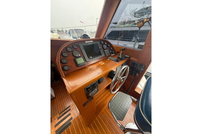 Slide: The Image of 2006 Island Pilot 395 helm with wooden dashboard, steering wheel, and navigation instruments. - 19