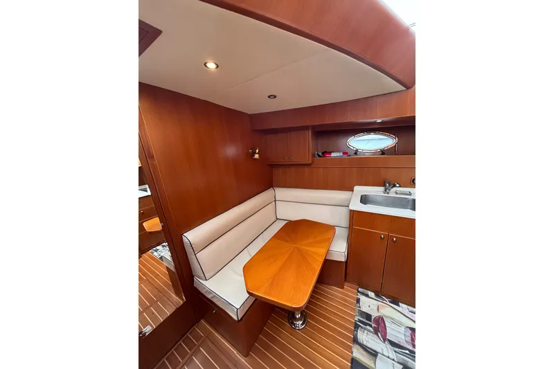 Slide: The Image of 2006 Island Pilot 395 interior with wooden dining area and compact kitchenette. - 29