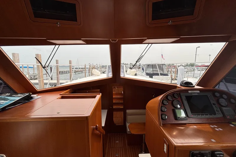 Slide: The Image of Interior view of 2006 Island Pilot 395 yacht cockpit with navigation controls and marina view. - 28