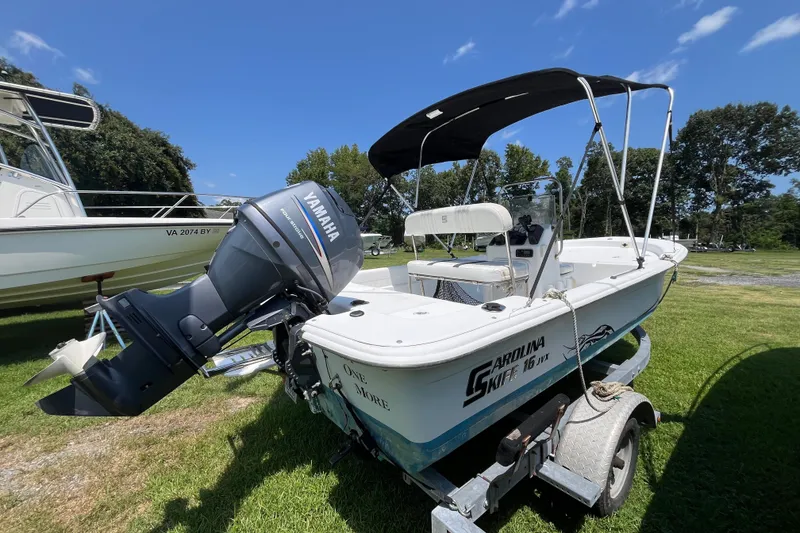 Slide: The Image of 2011 Carolina Skiff JVX16CC boat with Yamaha outboard motor on trailer, parked on grass. - 14