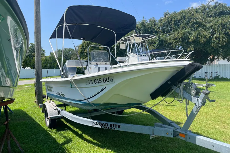 Slide: The Image of 2011 Carolina Skiff JVX16CC boat on trailer with canopy, parked on grass. - 17
