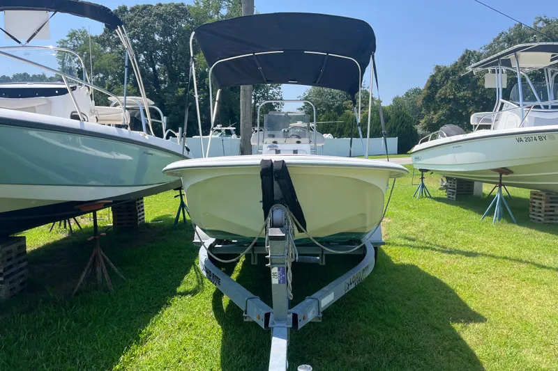 Slide: The Image of 2011 Carolina Skiff JVX16CC boat on trailer, parked on grass between other boats. - 16