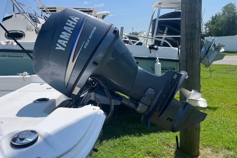 Slide: The Image of 2011 Carolina Skiff JVX16CC with Yamaha four-stroke outboard motor, docked on grass. - 18