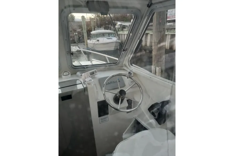 Slide: The Image of Interior view of 2022 May-Craft 2300 Pilot House boat cockpit with steering wheel. - 6