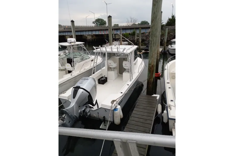 Slide: The Image of 2022 May-Craft 2300 Pilot House boat docked at marina. - 2