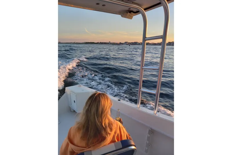 Slide: The Image of Woman enjoying sunset on a 2022 May-Craft 2300 Pilot House boat ride. - 9
