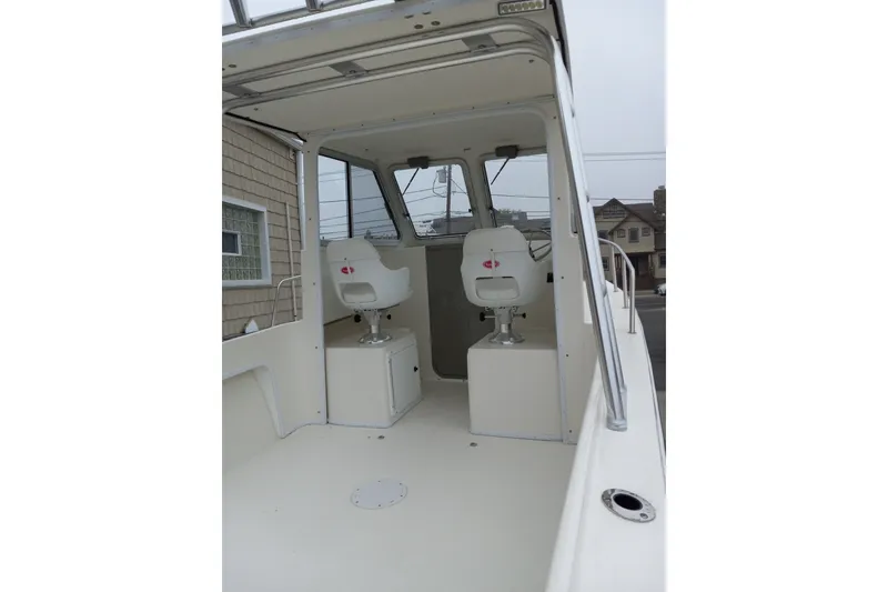 Slide: The Image of 2022 May-Craft 2300 Pilot House interior with two white captain chairs. - 8