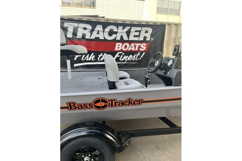 The Image of 2027 Bass Tracker Classic boat interior with steering wheel and seating, displayed at Tracker Boats showroom. - 1
