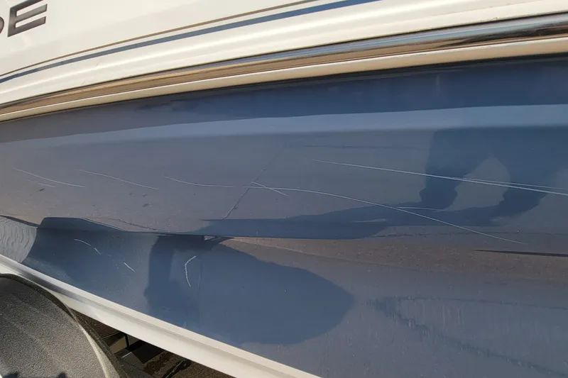 Slide: The Image of 2022 Tahoe 185 S boat with visible scratches on the blue hull. - 18