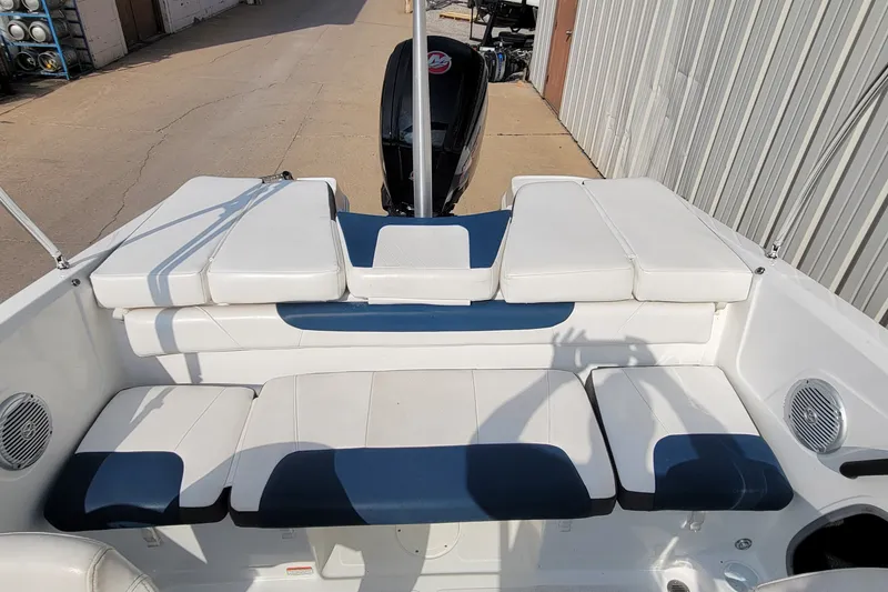 Slide: The Image of 2022 Tahoe 185 S boat interior with white and blue seating, docked outdoors. - 23