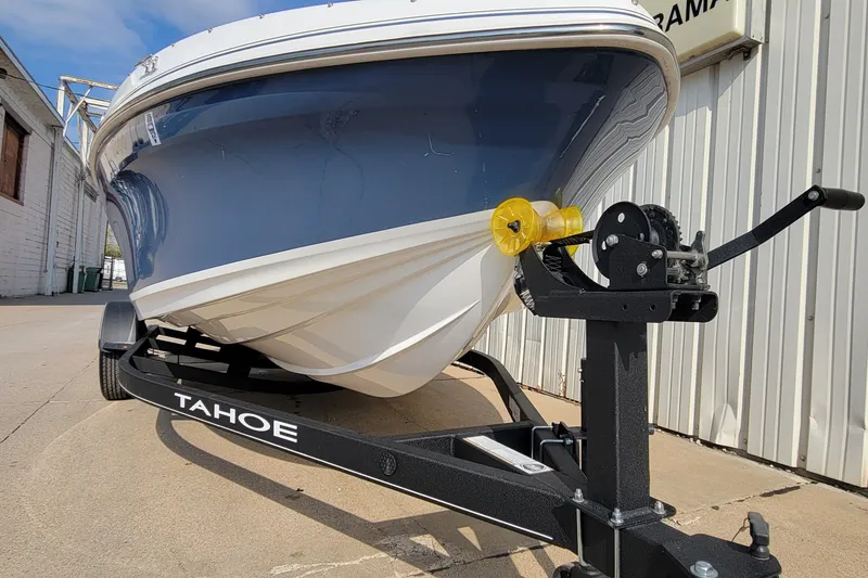 Slide: The Image of 2022 Tahoe 185 S boat on trailer, parked outdoors, showcasing sleek design and sturdy build. - 14