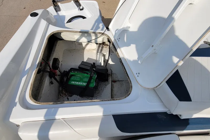 Slide: The Image of Open storage compartment in 2022 Tahoe 185 S boat with visible battery. - 22