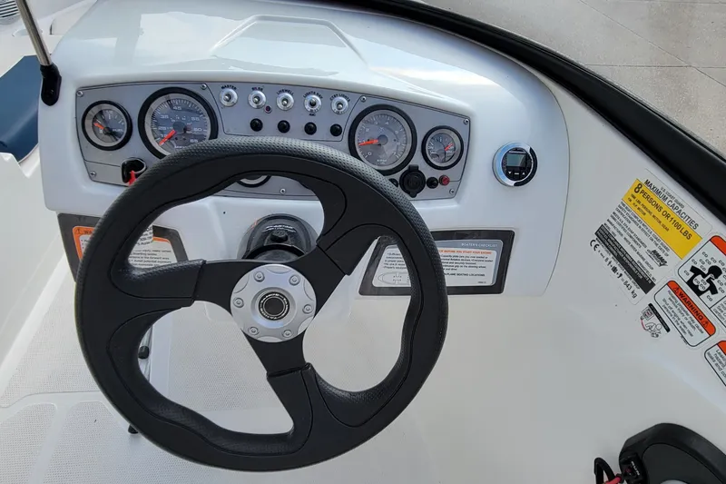 Slide: The Image of Steering wheel and dashboard of 2022 Tahoe 185 S boat with gauges and controls. - 27