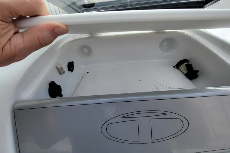 Slide: The Image of 2022 Tahoe 185 S boat storage compartment with open lid and visible logo. - 32