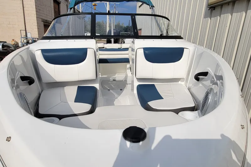 Slide: The Image of 2022 Tahoe 185 S boat interior with white and blue seating, docked outdoors. - 34