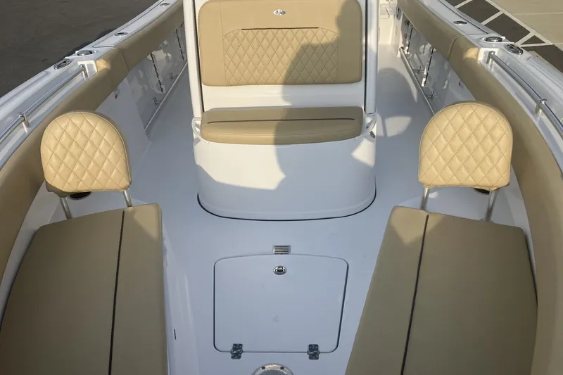 Slide: The Image of 2024 Sportsman Open 232 Center Console boat interior with beige cushioned seating. - 17