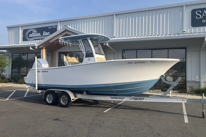 The Image of 2024 Sportsman Open 232 Center Console boat on trailer outside dealership. - 1