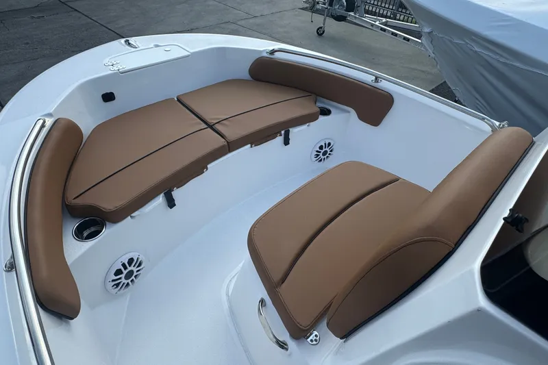 Slide: The Image of 2027 Stingray 17 CC boat interior with brown cushioned seating and built-in speakers. - 18