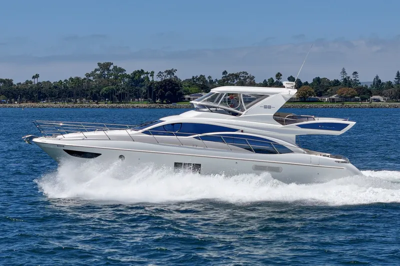 Slide: The Image of Luxury 2010 Azimut 58 yacht cruising on blue water near lush shoreline. - 19