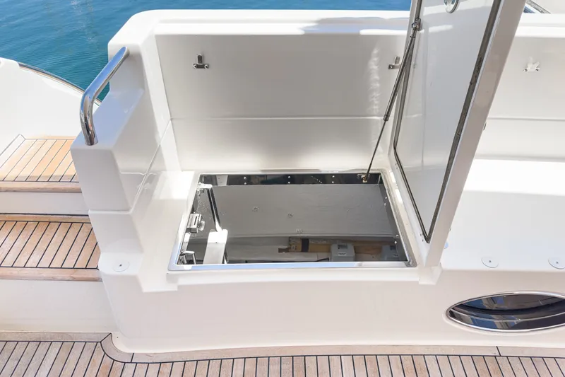 Slide: The Image of Open hatch on 2010 Azimut 58 yacht, revealing storage compartment, with teak deck flooring. - 97