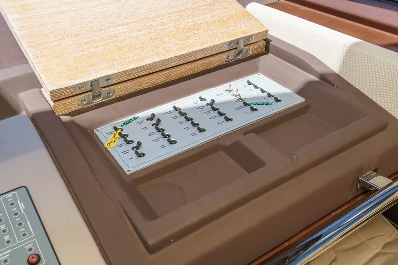 Slide: The Image of Control panel on a 2010 Azimut 58 yacht, featuring switches and a wooden cover. - 78