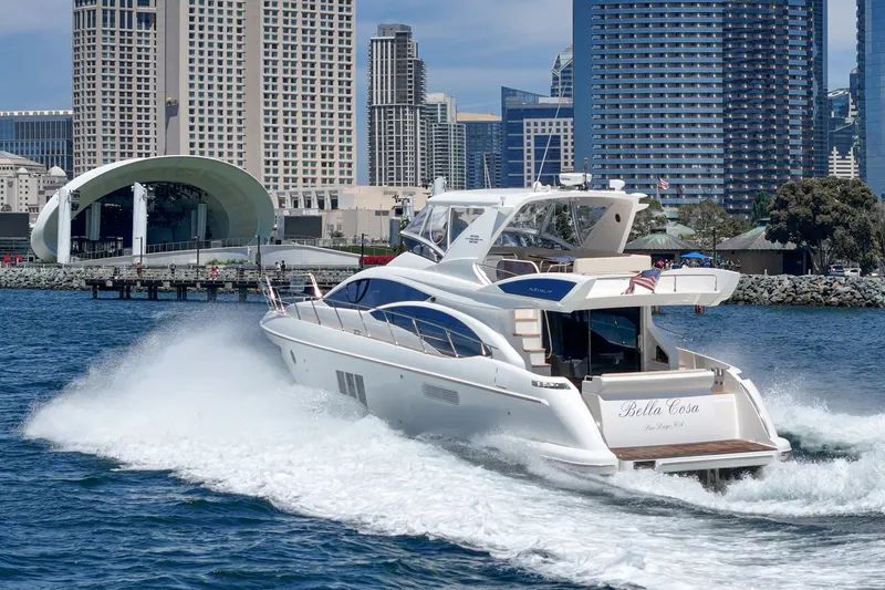 Slide: The Image of Azimut 58 yacht cruising near city skyline, 2010 model, creating waves in the water. - 29