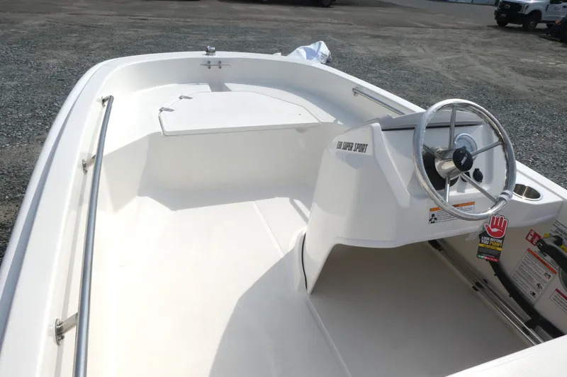Slide: The Image of 2027 Boston Whaler 130 Super Sport boat interior with steering wheel and seating area. - 8