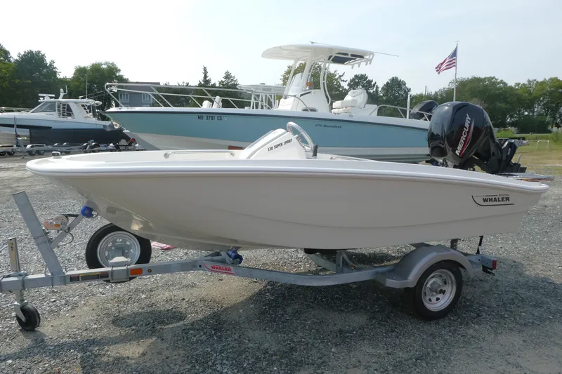 The Image of 2027 Boston Whaler 130 Super Sport boat on trailer, parked outdoors. - 0