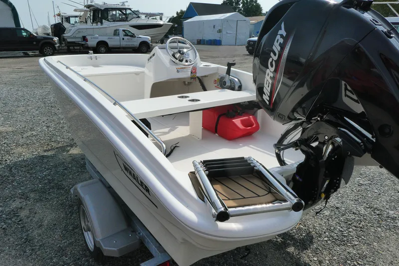 Slide: The Image of 2027 Boston Whaler 130 Super Sport boat with Mercury engine, parked on a trailer. - 3