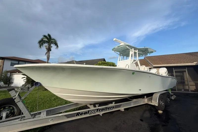The Image of 2019 Conch 30 boat on trailer, parked near palm tree and house. - 0