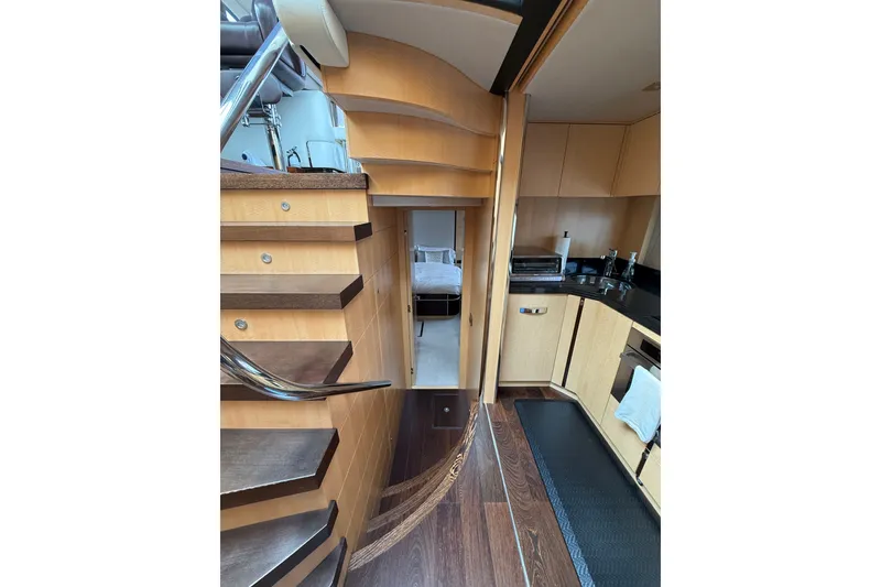 Slide: The Image of Interior view of 2014 Sunseeker Predator 68 yacht, featuring wooden stairs and modern kitchen area. - 46