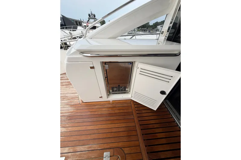 Slide: The Image of Sunseeker Predator 68 yacht deck with open storage compartment, showcasing sleek design and wood flooring. - 18