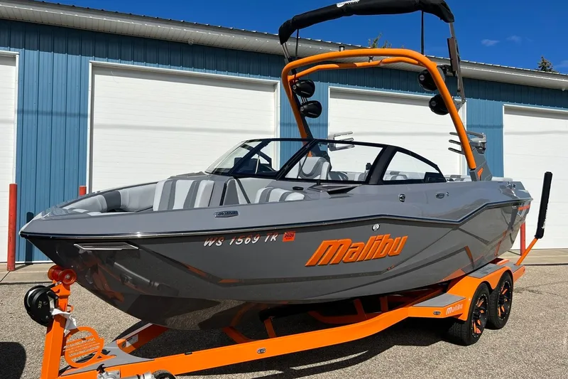 Slide: The Image of 2023 Malibu Wakesetter 22 LSV boat with orange accents on a trailer. - 3