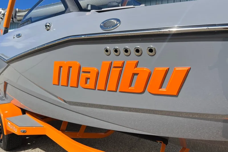 Slide: The Image of 2023 Malibu Wakesetter 22 LSV boat with bold orange branding. - 7