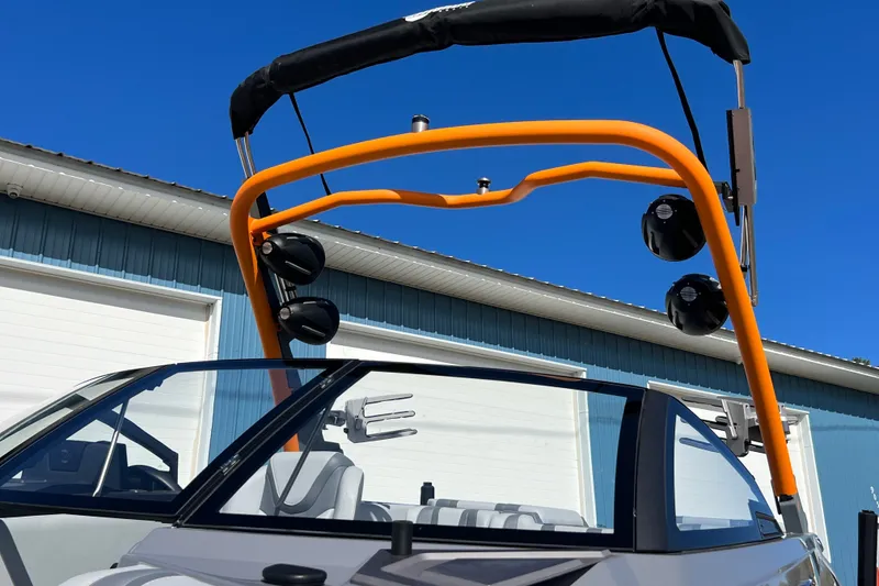 Slide: The Image of 2023 Malibu Wakesetter 22 LSV with orange wakeboard tower and speakers, under clear blue sky. - 35