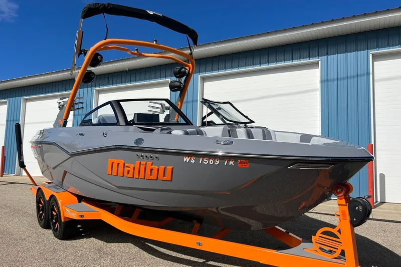Slide: The Image of 2023 Malibu Wakesetter 22 LSV boat on trailer, parked outside blue building. - 4