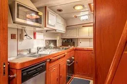Slide: The Image of 1987 Camper & Nicholsons cruising sailboat interior kitchen with wooden cabinetry and modern appliances. - 25