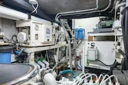 Slide: The Image of Engine room of a 1987 Camper & Nicholsons cruising sailboat, showcasing mechanical equipment and piping. - 32