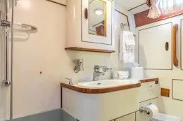 Slide: The Image of 1987 Camper & Nicholsons sailboat bathroom with sink, mirror, and storage cabinets. - 29