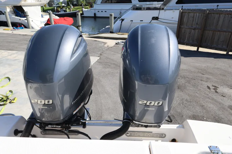 Slide: The Image of Twin Yamaha 200 engines on a 2023 Robalo R242 Explorer boat at a marina. - 22
