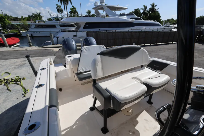 Slide: The Image of 2023 Robalo R242 Explorer boat interior with seating, docked near luxury yachts. - 19