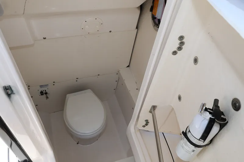 Slide: The Image of 2023 Robalo R242 Explorer boat interior with toilet and fire extinguisher. - 18
