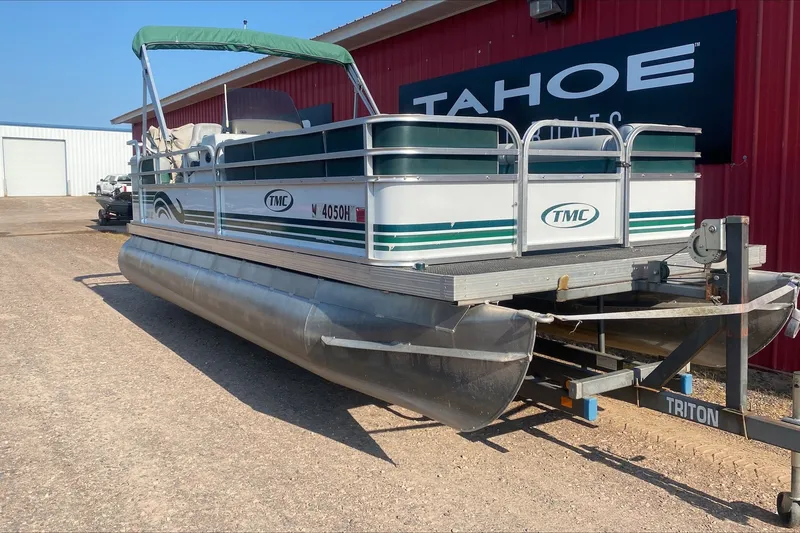 The Image of 2007 TMC 2200LE pontoon boat on trailer, parked outside Tahoe Boats building. - 1