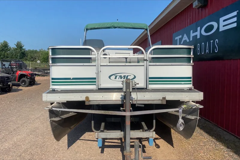 Slide: The Image of 2007 TMC 2200LE pontoon boat on trailer, parked outside Tahoe Boats dealership. - 7