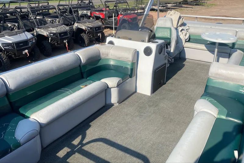 Slide: The Image of Interior of a 2007 TMC 2200LE pontoon boat with green and gray seating. - 2