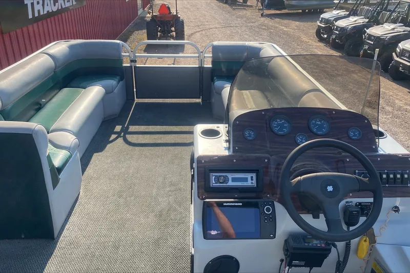Slide: The Image of Interior of a 2007 TMC 2200LE pontoon boat with steering console and seating. - 4
