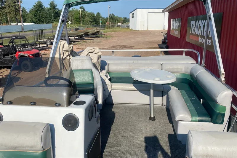 Slide: The Image of Pontoon boat interior with seating and table, TMC 2200LE, 2007 model, parked outdoors. - 3