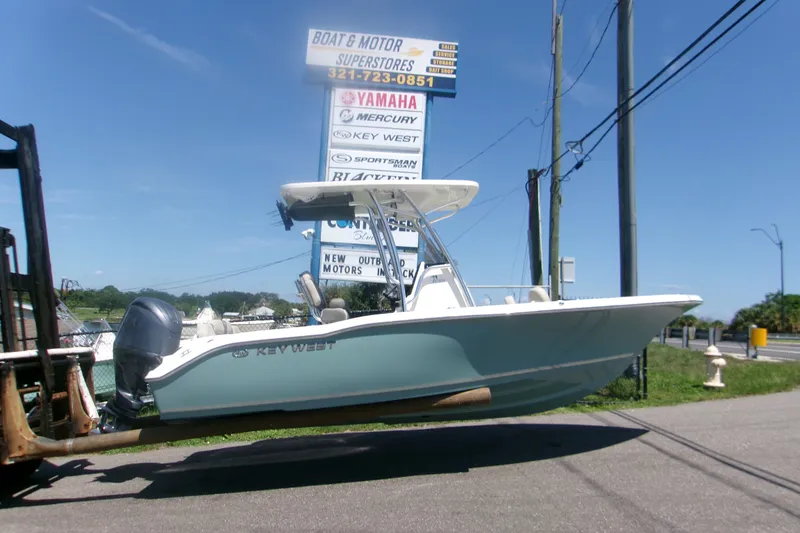 The Image of 2027 Key West 219 FS boat displayed at dealership with clear blue sky background. - 1